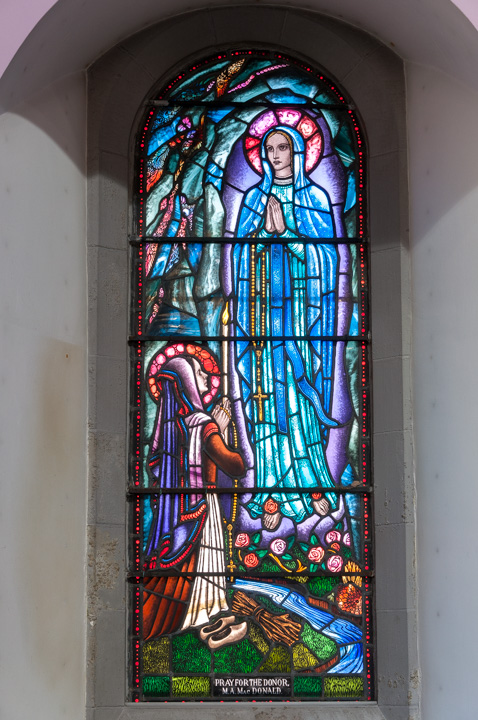 stained glass window with Bernadette and the Virgin Mary